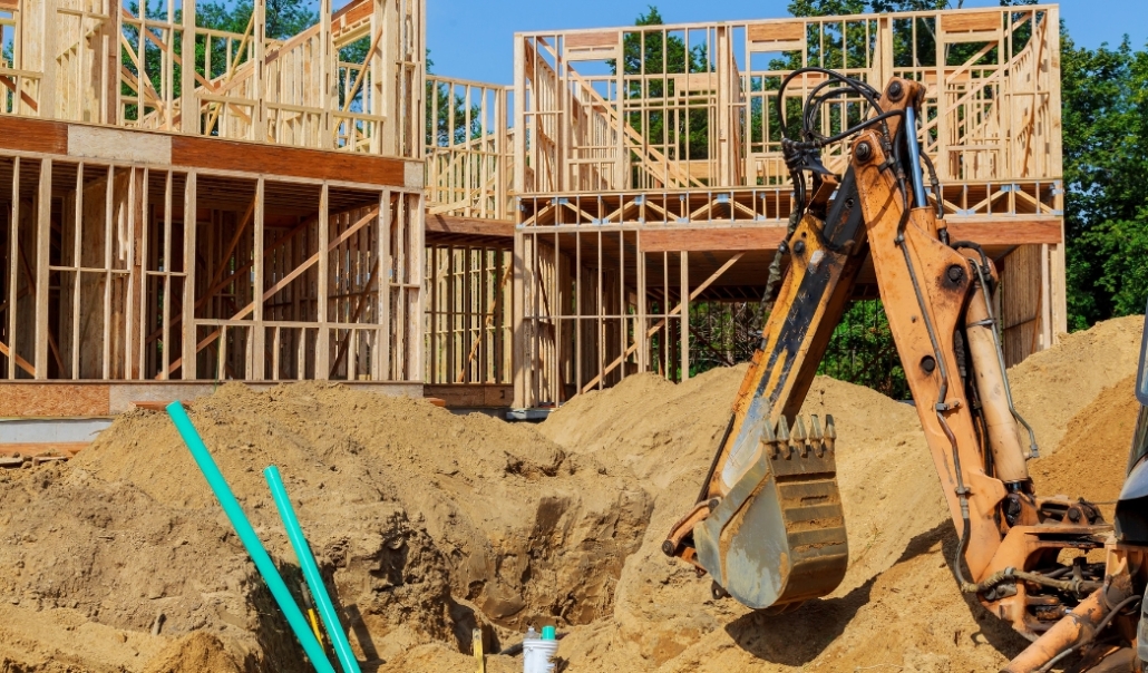 A construction worker is on-site, working on a house, highlighting the construction and management of custom home design.