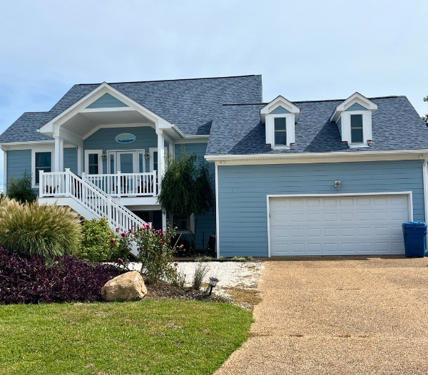 A blue house with a garage and driveway, illustrating remodeling services aimed at boosting home resale value in Virginia Beach.