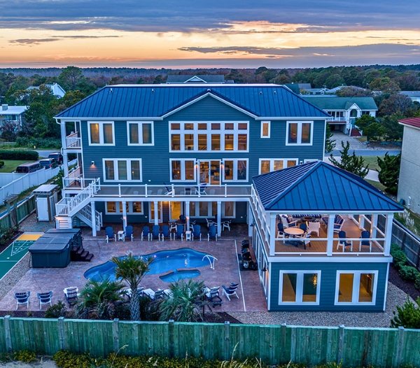 A prominent blue residence with a pool and deck, highlighting Coastal Experience's remodeling services in Virginia Beach.