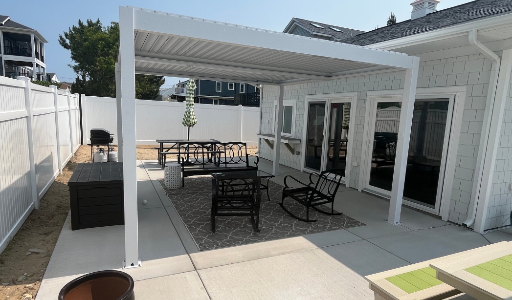 A stylish covered patio with outdoor seating, representing exterior remodeling services available in Virginia Beach.
