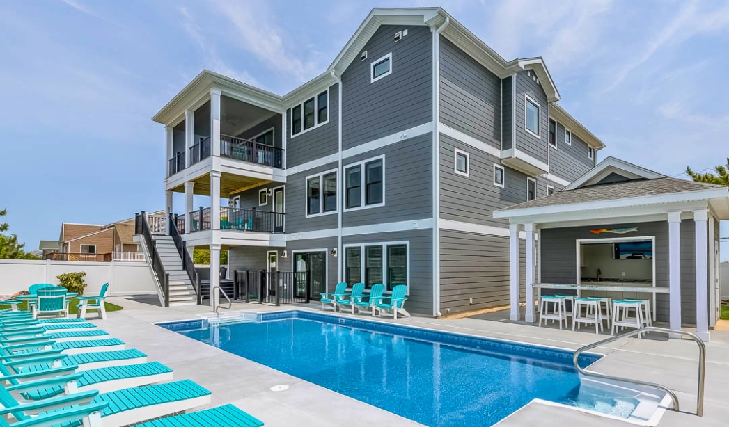 A Virginia Beach home by Baycliff, complete with a pool and deck chairs, perfect for leisure and relaxation.