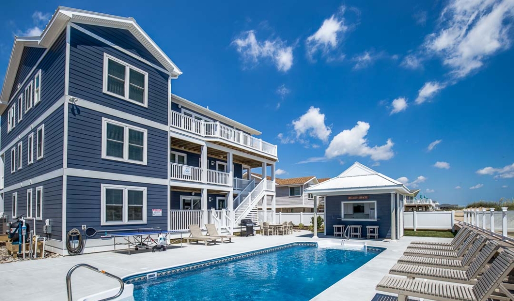Villa Sol, a blue house featuring a pool and deck, designed by Croatan Virginia Beach Home Builders.