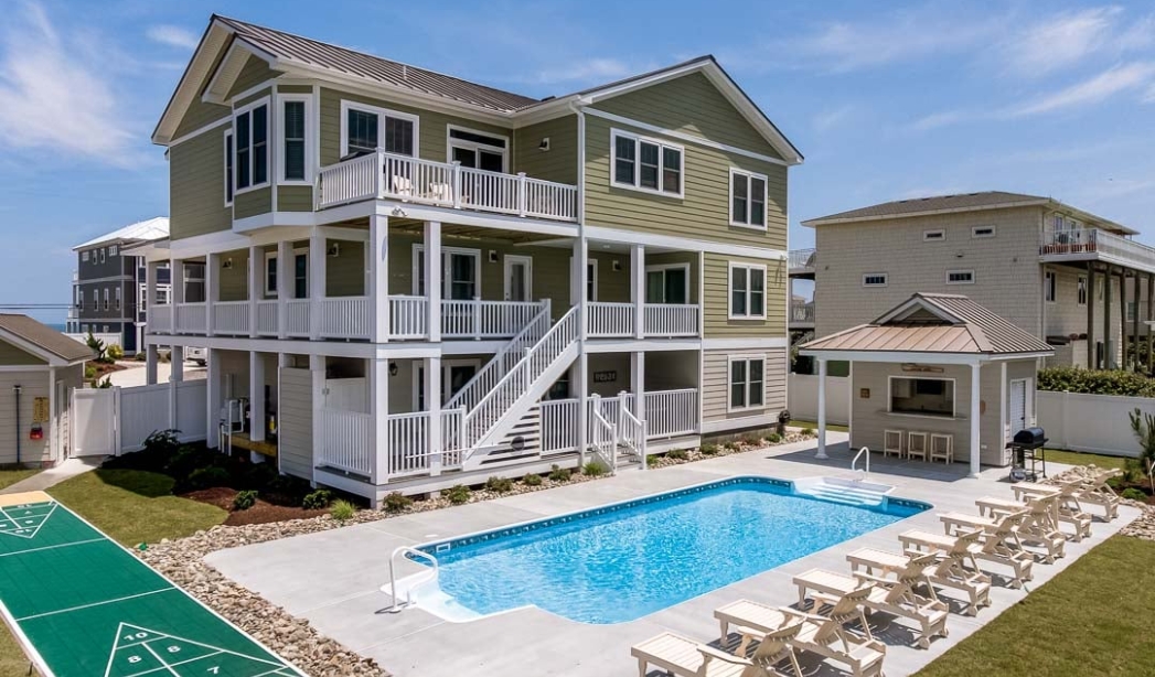 A modern house featuring a pool and deck, showcasing the craftsmanship of Amazing Grace Home Builders in Great Neck, Virginia Beach.