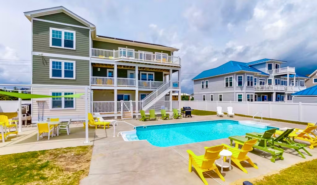 A modern house with a pool and lawn chairs, showcasing the Indian River Virginia Beach Homebuilders