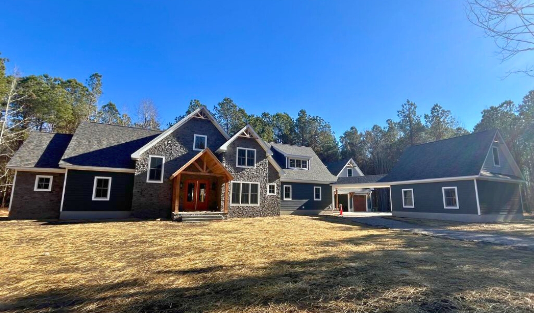 A large home with black siding and windows, showcasing modern architecture in Little Neck, Virginia Beach.