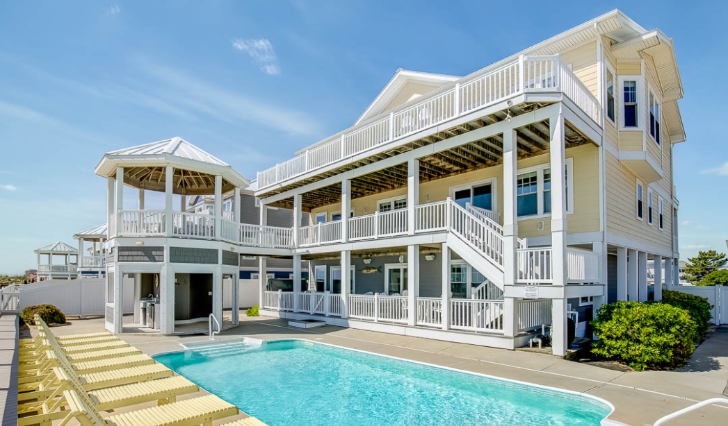 A modern house featuring a pool and deck, showcasing the craftsmanship of Amazing Grace builders in North End Virginia Beach.