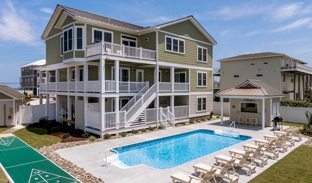 A stylish home with a pool and deck, highlighting the design by Amazing Grace, located in North End Virginia Beach.