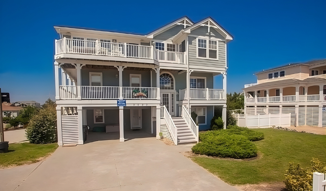 A charming beach house with a wide porch and stairs, created by Ocean Lakes Virginia Beach Homebuilders