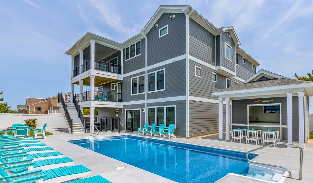 Exterior view of a spacious house featuring a pool and deck, representing Pungo Virginia Beach Home Builders' style.