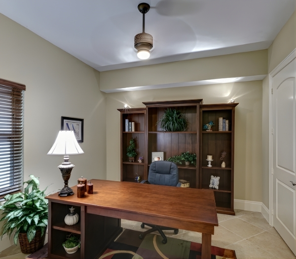 A modern home office setup with a desk, lamp, and bookshelf, showcasing custom design solutions in Virginia Beach.
