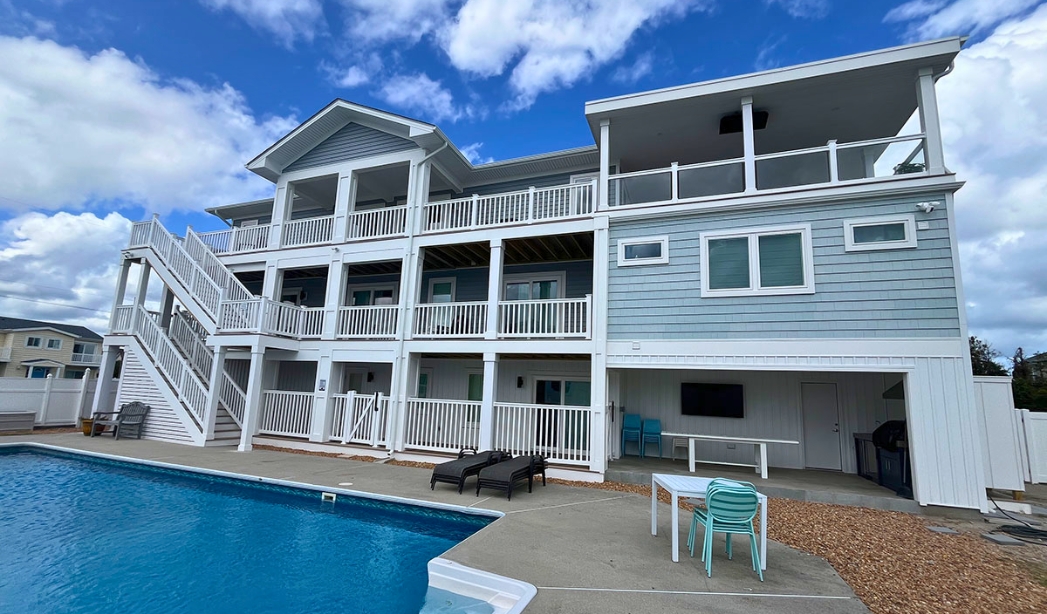 Exterior view of a spacious house with a pool and stairs, highlighting a remodel project in Virginia Beach.