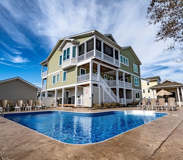 A stylish house with a pool and deck, representing a Virginia Beach contractor's commitment to timely and budget-friendly builds.