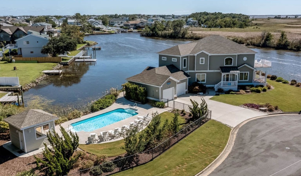 A Virginia Beach residence with a pool and dock, representing a summer getaway by Summer Baycation.