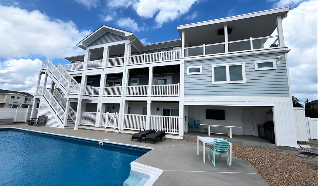 A renovated multi-level coastal residence featuring spacious covered decks, durable exterior finishes, and a private pool area, showcasing RBC Homes’ expertise in large-scale remodels designed for comfort.