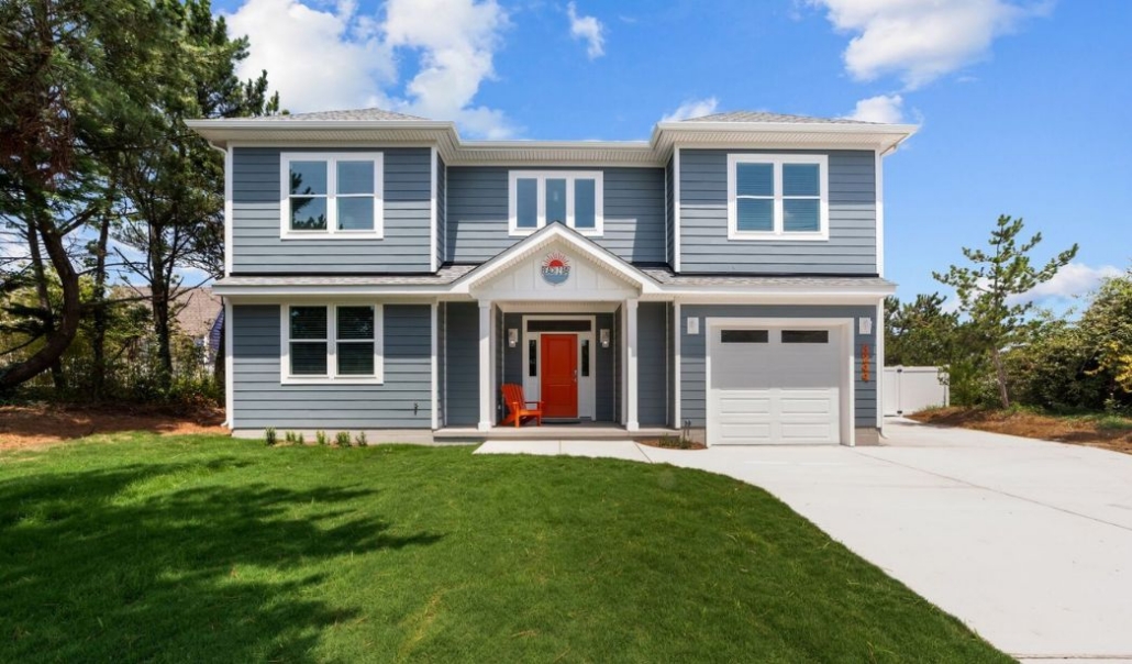 Gray two-story home featuring composite lap siding, white trim, and a bright red front door.