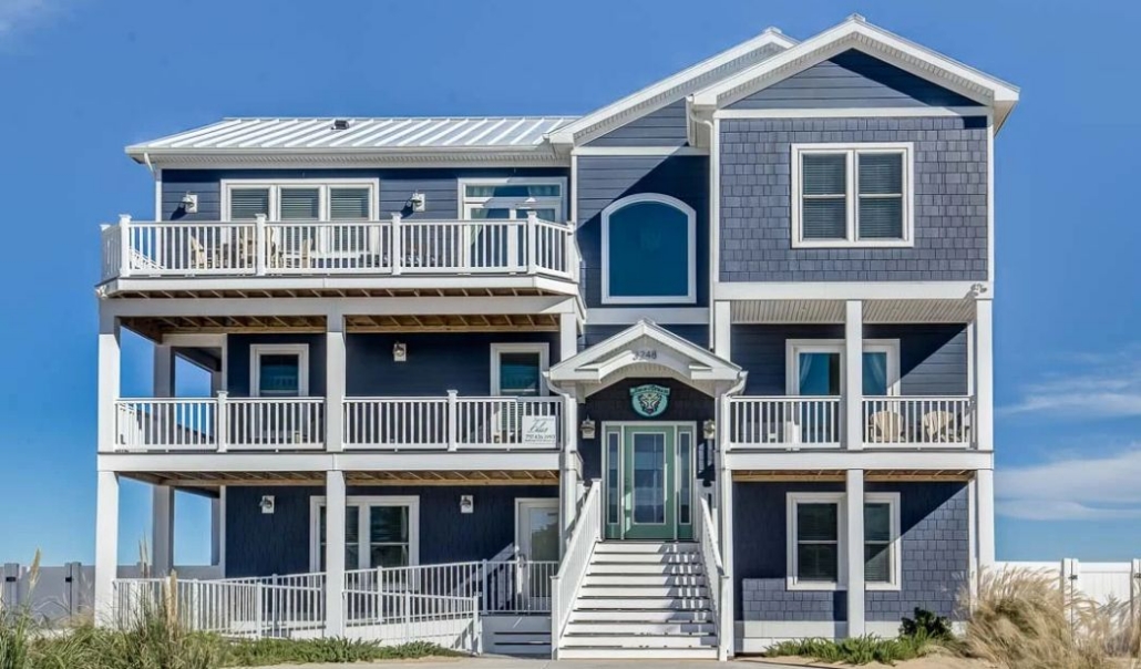 Coastal beach house featuring natural cedar shingle siding and multiple covered balconies.