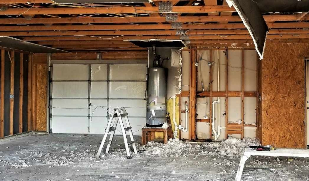 A garage featuring a wood ceiling and a ladder, part of a project to convert it into a home office with structural modifications.
