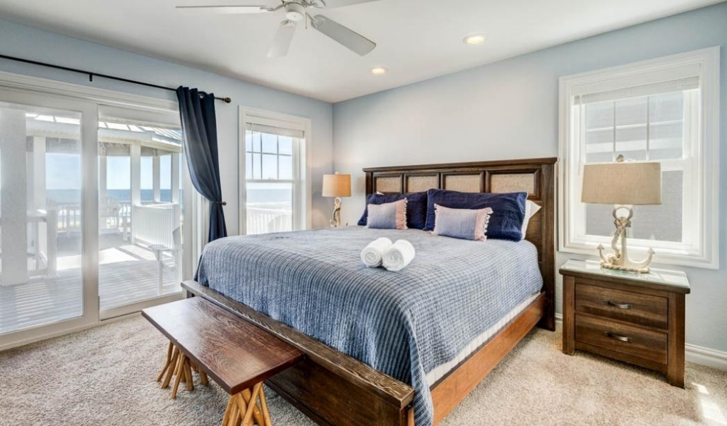 A stylish bedroom suite with a bed and a window that offers a scenic ocean view.