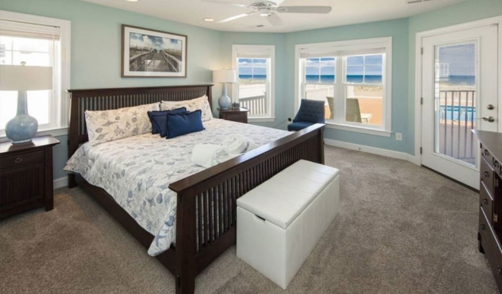Elegant master bedroom with a bed and ocean-view window, designed to maximize your home's value.