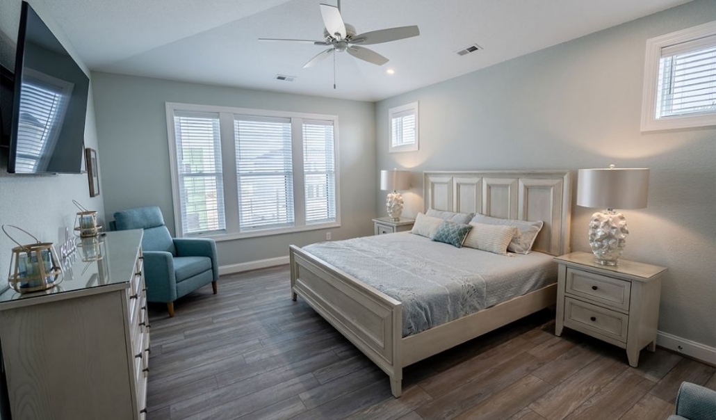 A well-furnished master bedroom suite showing a bed, dresser, and ceiling fan, included in the planning phase.