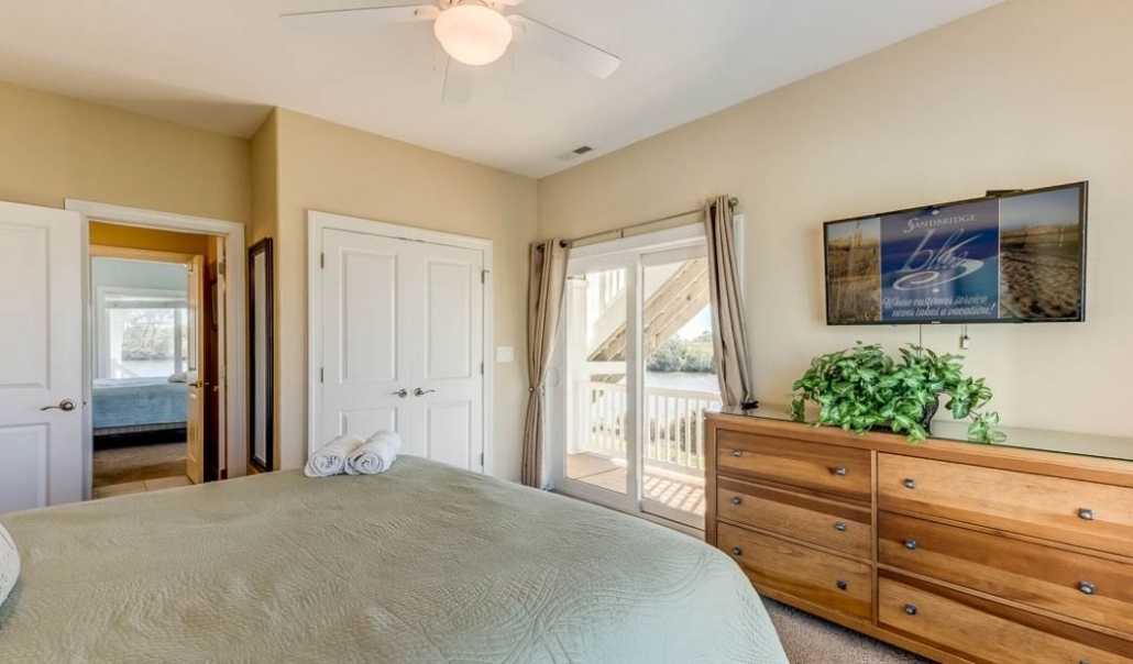 Spacious master bedroom suite with a cozy bed and a flat-screen TV for entertainment.