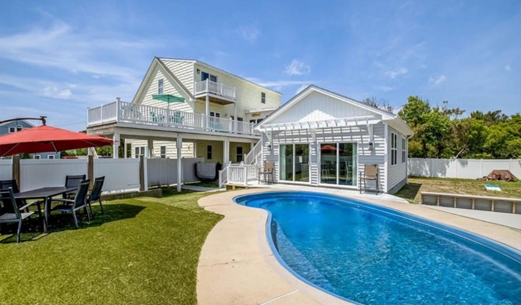 Coastal custom home featuring outdoor entertaining areas, pool access, and open living design.