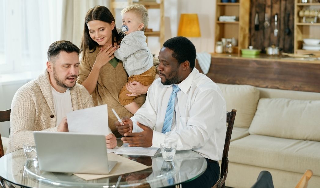 Family reviews investment property analysis with a real estate agent in a Virginia Beach home.