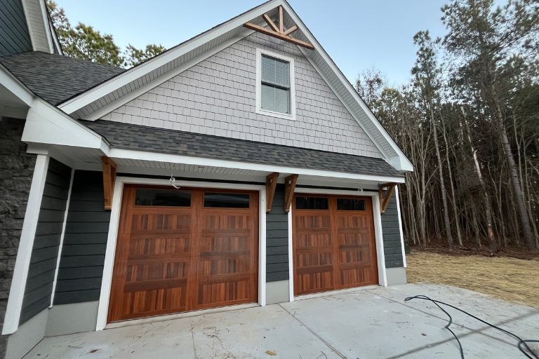 Attached garage addition with wood doors on a custom Virginia Beach home.