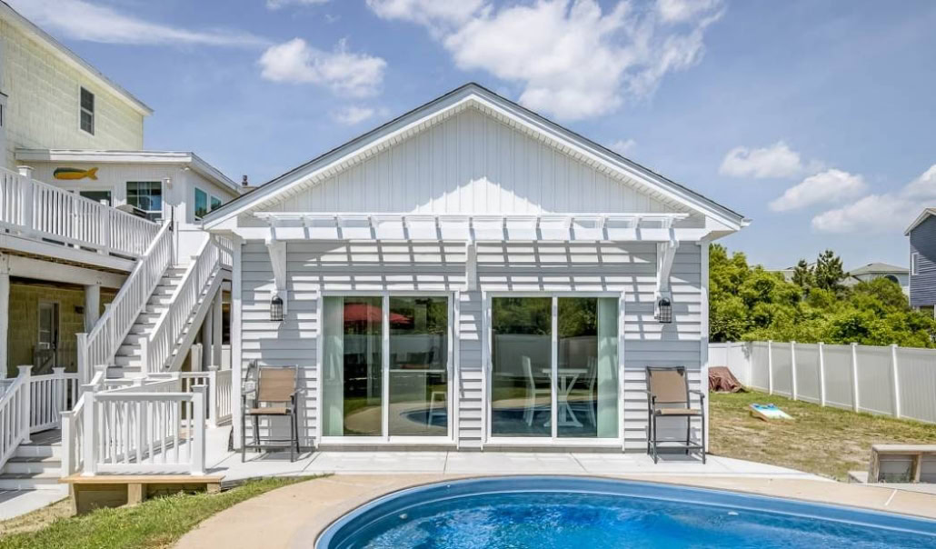 Detached poolside structure with sliding glass doors, illustrating an accessory dwelling unit (ADU).